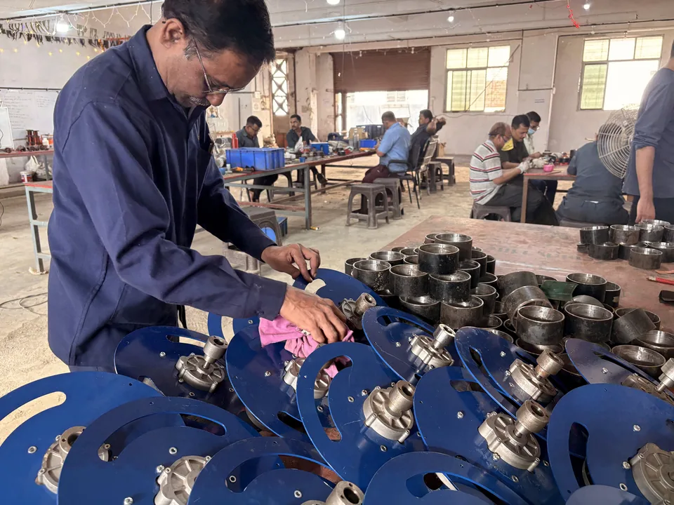 Source photograph of a worker handling valve components at a workbench